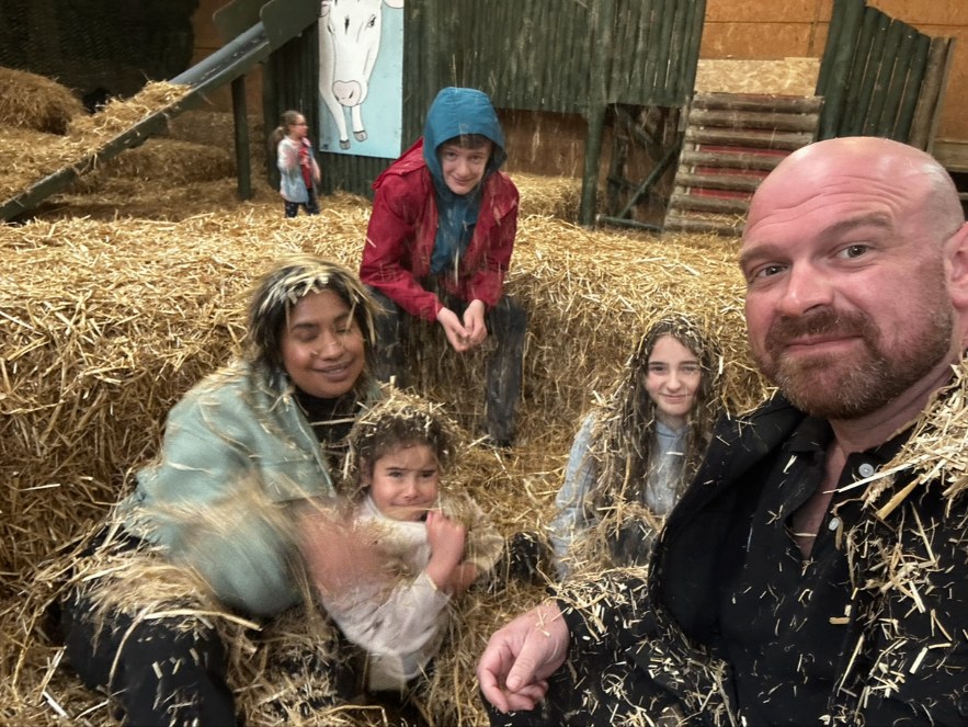 Daniel with his family playing in the hay